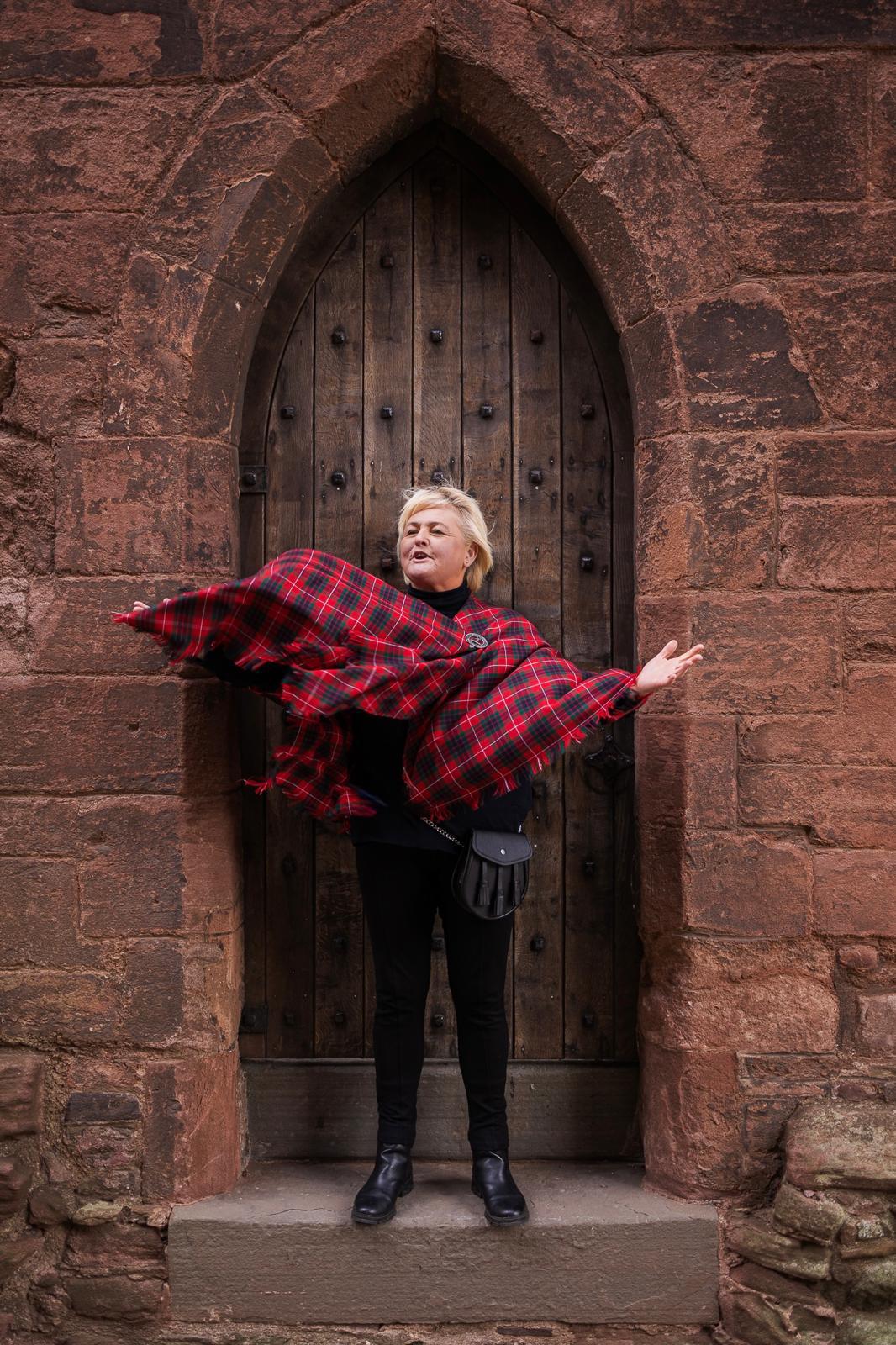 Victoria wearing tartan at a rustic stone venue