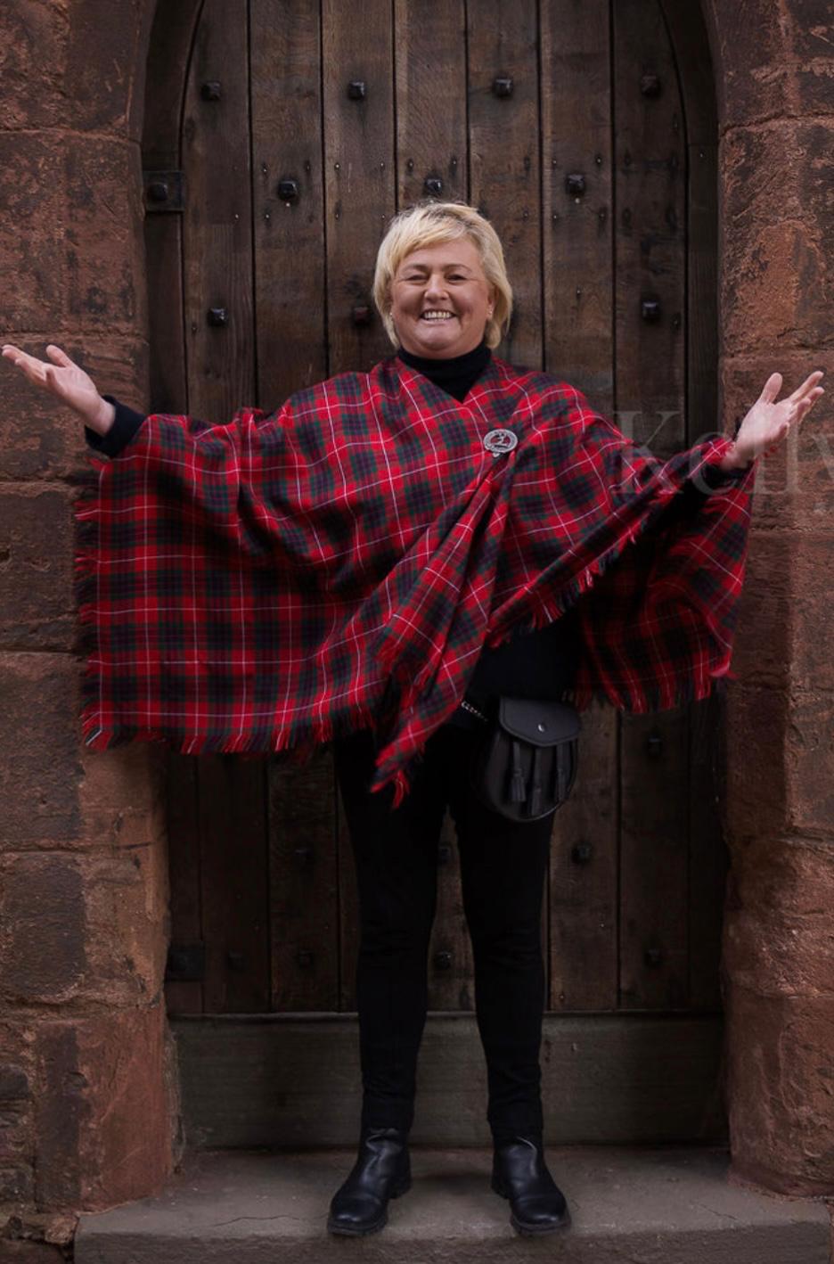 Victoria holding out a length of red tartan